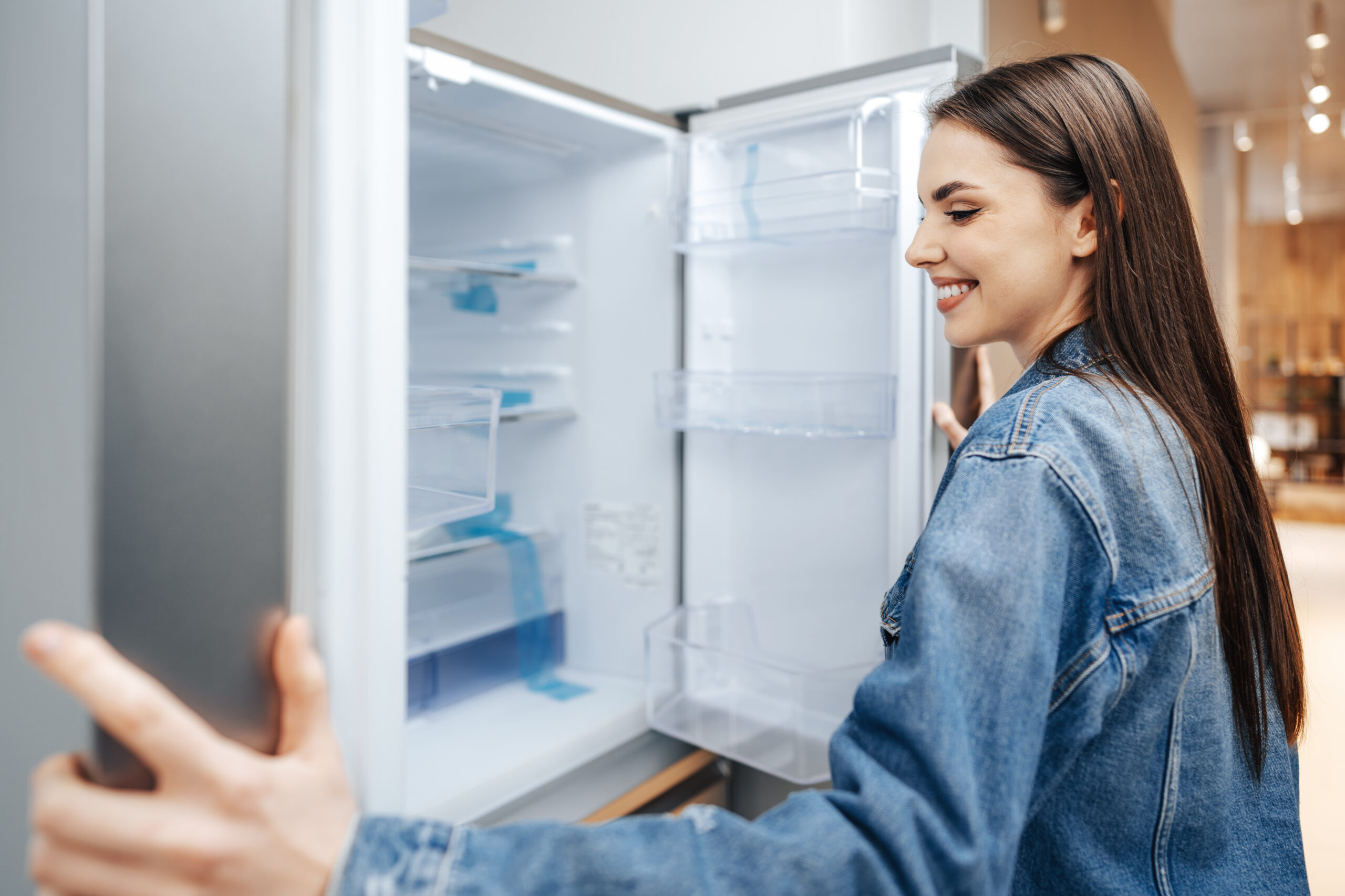 mujer atractiva joven eligiendo frigorifico hipermercado 1 scaled